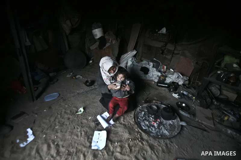 A Palestinian mother eating her child at their house inbetween makeshift tents in one of the most poor regions in Al-Nusirat neighborhood, central Gaza Strip on 28 February 2012. The United Nations Relief and Works Agenc...