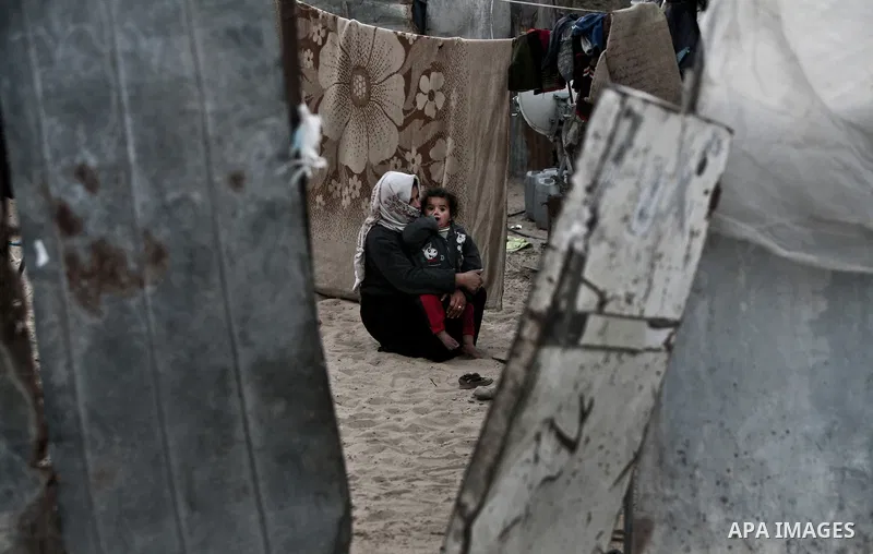 A Palestinian mother Embraces her child at their house inbetween makeshift tents in one of the most poor regions in Al-Nusirat neighborhood, central Gaza Strip on 28 February 2012. The United Nations Relief and Works Age...