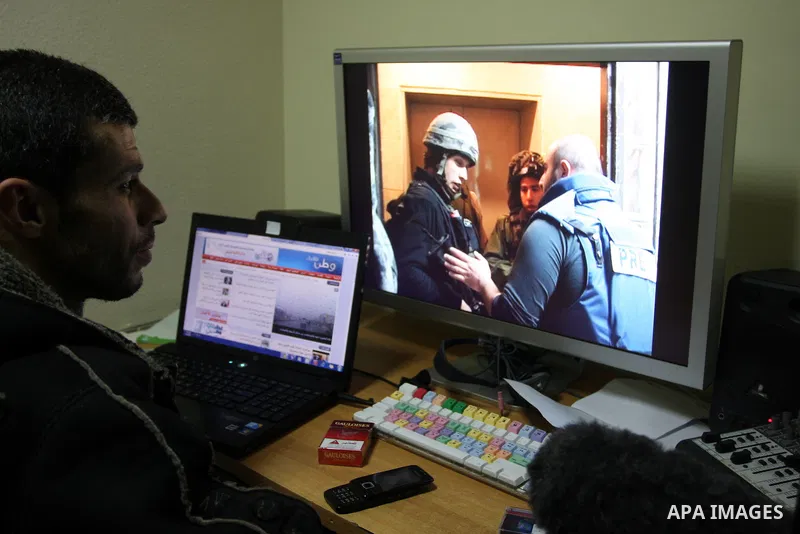 Staff members of a local private television station "Watan", look at the damage caused after Israeli troops raided this and another Palestinian television station in the West Bank city of Ramallah overnight, seizing comp...