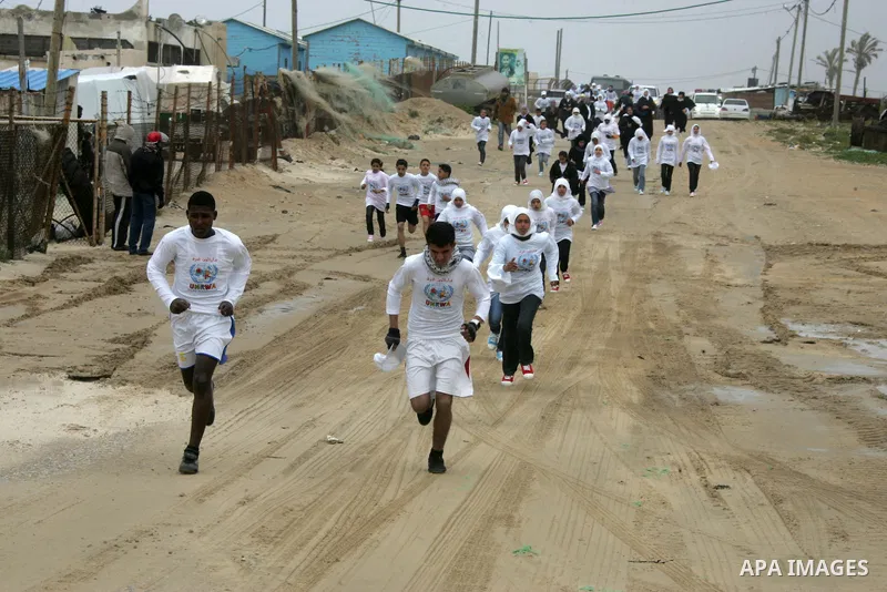 Participants warm up before competing in the UN-sponsored Gaza marathon in Rafah town, in the southern Gaza Strip on March 1, 2012. Thousands of runners braved temperatures hovering just above zero degrees centigrade to...