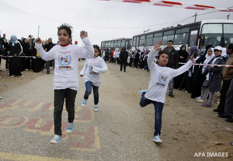 Participants warm up before competing in the UN-sponsored Gaza marathon in Rafah town, in the southern Gaza Strip on March 1, 2012. Thousands of runners braved temperatures hovering just above zero degrees centigrade to...