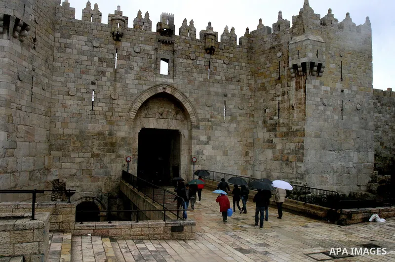 Palestinians walk in a street during the heavy rain and cold winds at the Al-Aqsa Mosque compound in Jerusalem's Old City, on Mar. 01, 2012. Photo by Mahfouz Abu Turk