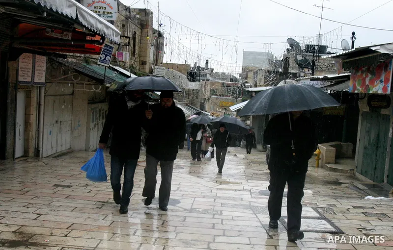 Palestinians walk in a street during the heavy rain and cold winds in Jerusalem's Old City, on Mar. 01, 2012. Photo by Mahfouz Abu Turk
