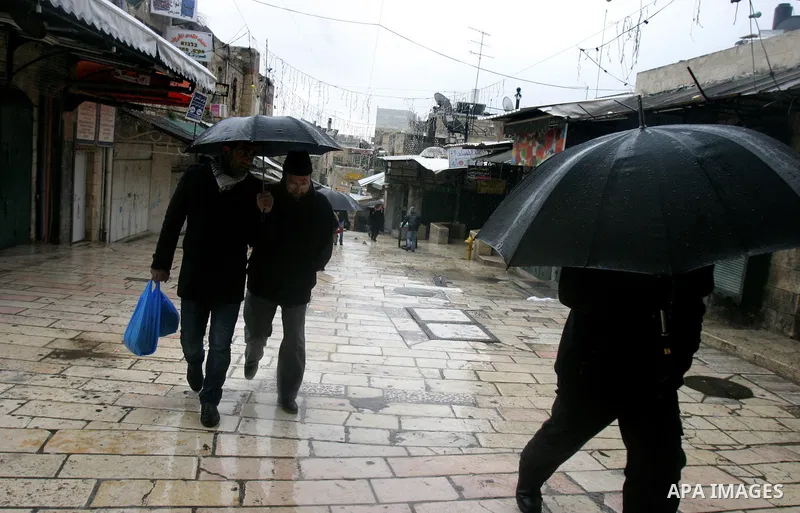 Palestinians walk in a street during the heavy rain and cold winds in Jerusalem's Old City, on Mar. 01, 2012. Photo by Mahfouz Abu Turk