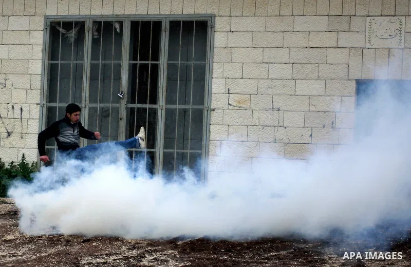 A Palestinian protester kicks back a tear gas canisters fired by Israeli soldiers during a demonstration against the expropriation of Palestinian land by Israel in the village of Kfar Qaddum, near the West Bank city of N...