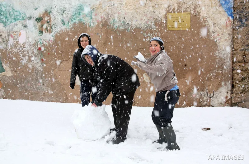 Jewish youths throw snowballs as they play next to Israeli army position in the West Bank city of Hebron as wintry weather swept through the region on March 2, 2012. Photo by Mamoun Wazwaz