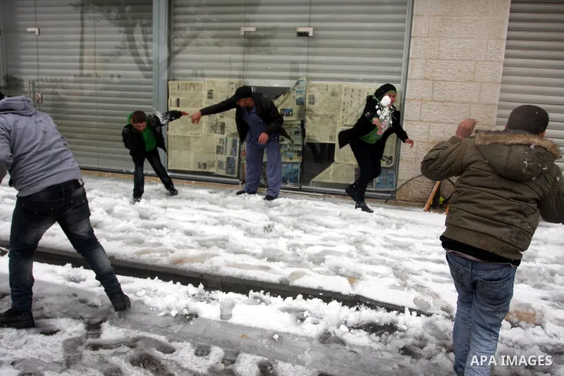 Palestinians throw snowballs in the West Bank city of Ramallah as wintry weather swept through the region on March 2, 2012. Photo by Issam Rimawi