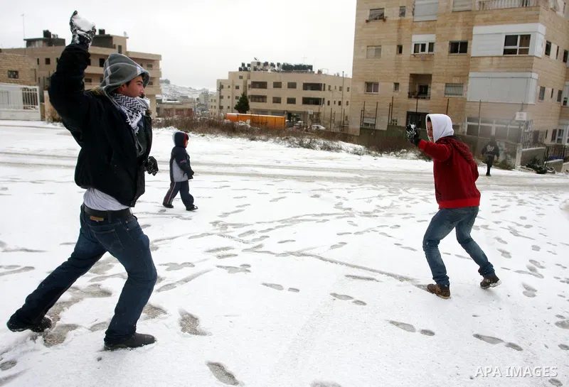 Palestinians throw snowballs in the West Bank city of Ramallah as wintry weather swept through the region on March 2, 2012. Photo by Issam Rimawi