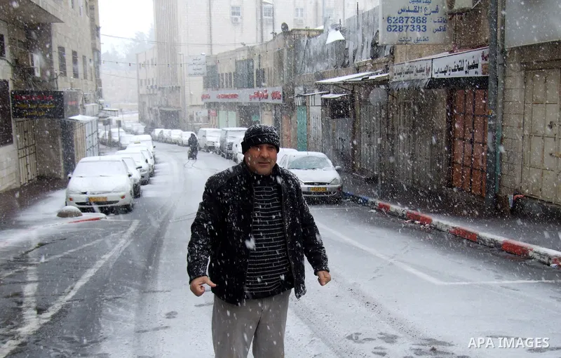 A Palestinian man walks through snow in Jerusalem March 2, 2012. Snow fell in Jerusalem on Friday morning. Local media reported this was the first time in four years that snow had fell in Jerusalem causing schools to clo...