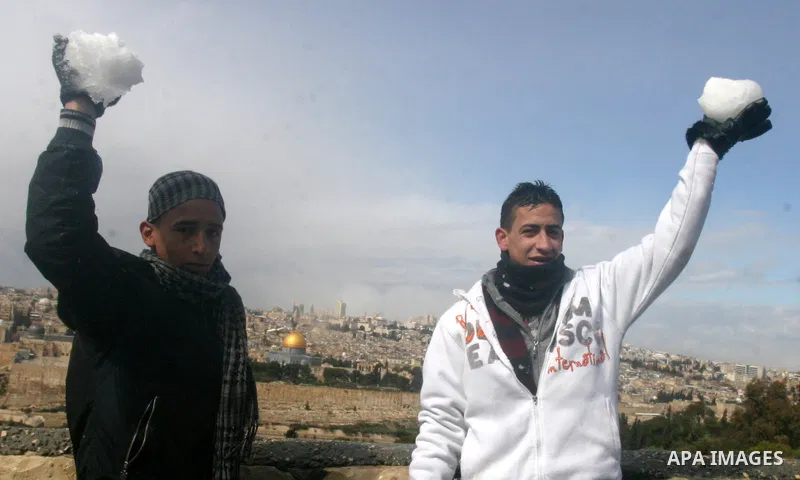 Palestinian youths play with snow in Jerusalem March 2, 2012. Snow fell in Jerusalem on Friday morning. Local media reported this was the first time in four years that snow had fell in Jerusalem causing schools to close...