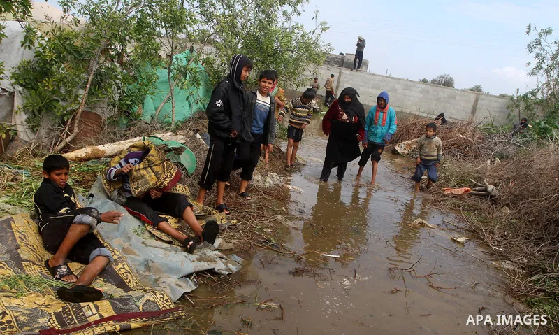 Palestinian Bedouin children walk through muddy waters after heavy rains which flooded the Al Moghraka area in the central Gaza Strip, 04 March 2012. Photo by Ashraf Amra