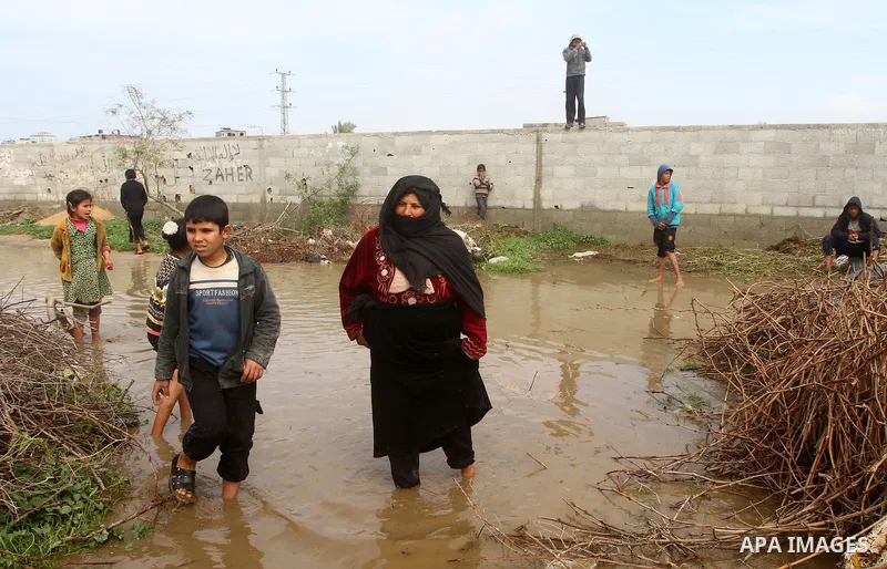 Palestinian Bedouin children walk through muddy waters after heavy rains which flooded the Al Moghraka area in the central Gaza Strip, 04 March 2012. Photo by Ashraf Amra