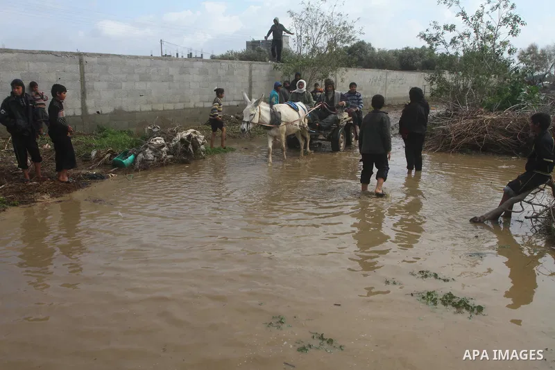 Palestinian Bedouin children walk through muddy waters after heavy rains which flooded the Al Moghraka area in the central Gaza Strip, 04 March 2012. Photo by Ashraf Amra