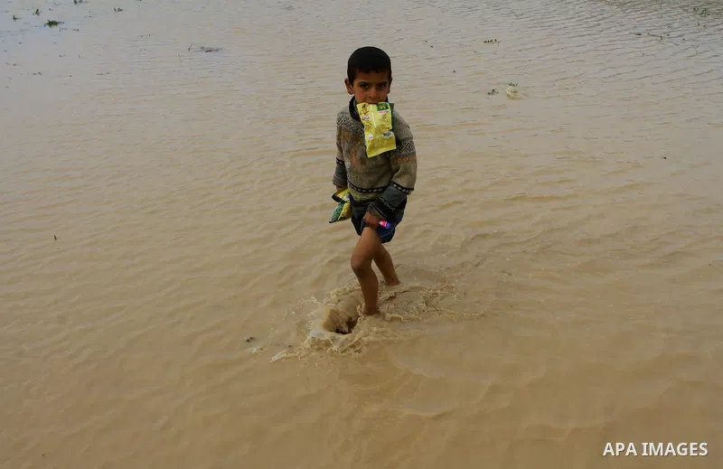 Palestinian Bedouin children walk through muddy waters after heavy rains which flooded the Al Moghraka area in the central Gaza Strip, 04 March 2012. Photo by Ashraf Amra