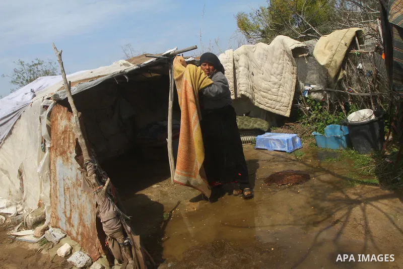 Palestinian Bedouin woman walk through muddy waters after heavy rains which flooded the Al Moghraka area in the central Gaza Strip, 04 March 2012. Photo by Ashraf Amra