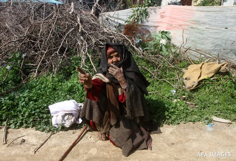 A Palestinian woman sits outside her dwelling in al-Mugraga in the central Gaza Strip, after a few days of heavy rain March 4, 2012. Photo by Ashraf Amra