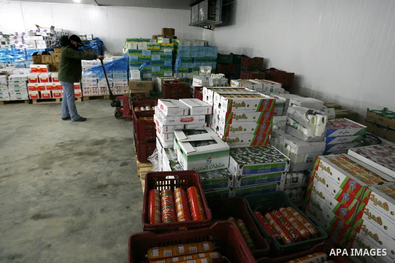 Palestinian workers employed in the warehouses of refrigerators for goods in Nusseirat refugee camp in central Gaza Strip on March 5, 2012. While the owners of freezers traders suffer from power cuts and lack of diesel f...