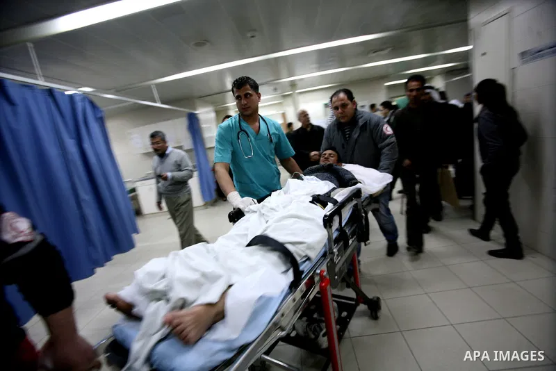 Palestinian paramedic examines a youth injured in an explosion, in the emergency room of a hospital in the West Bank city of Hebron March 6, 2012. Two Palestinian children were killed and three teenagers were injured whe...