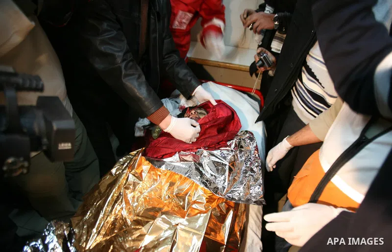 Palestinian medics bring the bodies of two children into a morgue in the West Bank city of Hebron, 06 March 2012. The Palestinian children apparently were killed while handling munitions which they collected from an Isra...