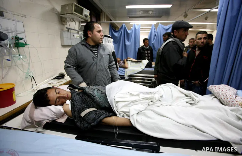 Palestinian paramedic examines a youth injured in an explosion, in the emergency room of a hospital in the West Bank city of Hebron March 6, 2012. Two Palestinian children were killed and three teenagers were injured whe...