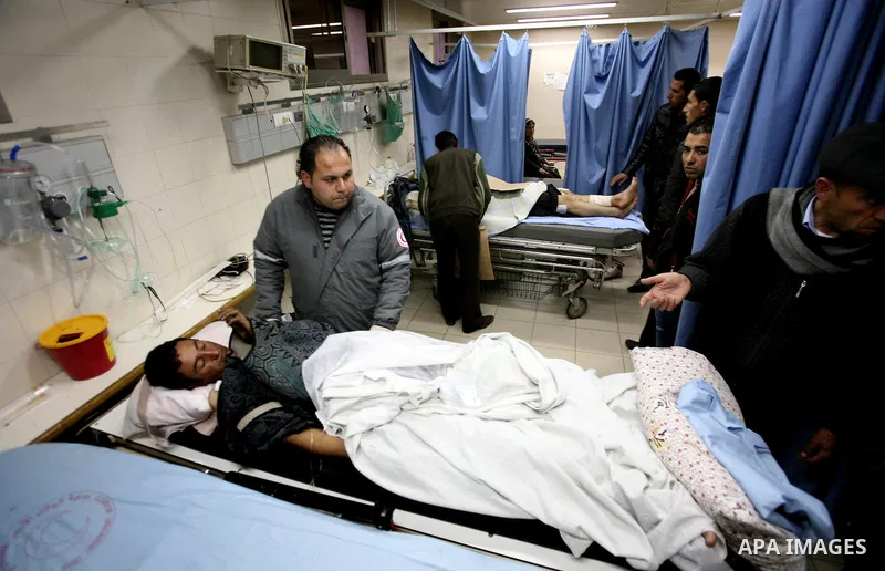 Palestinian paramedic examines a youth injured in an explosion, in the emergency room of a hospital in the West Bank city of Hebron March 6, 2012. Two Palestinian children were killed and three teenagers were injured whe...