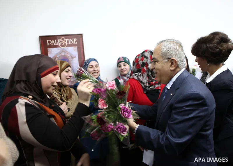 Palestinian Prime Minister, Salam Fayyad, honors women work in the Ministry of Housing and Public Works during a celebration organized on the occasion of Women's Day in the West Bank city of Ramallah, on Mar. 07, 2012. P...