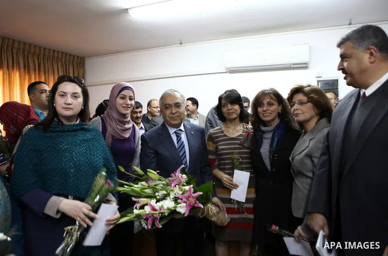 Palestinian Prime Minister, Salam Fayyad, honors women work in the Ministry of Housing and Public Works during a celebration organized on the occasion of Women's Day in the West Bank city of Ramallah, on Mar. 07, 2012. P...