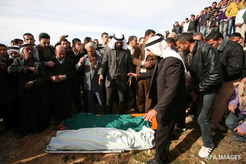 Palestinian mourners pray next to the bodies of two boys who were killed the previous day when unexploded military ordinance detonated outside Hebron, during their funeral in Wadi al-Rim, West Bank, 07 March 2012. Palest...