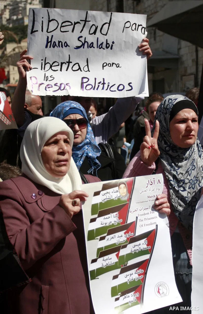 Palestinian women carry banners as they mark International Women's Day in solidarity with Hana Shalabi, a Palestinian prisoner jailed in Israel and who has been on hunger strike for 22 days, in the West Bank in Nablus, T...
