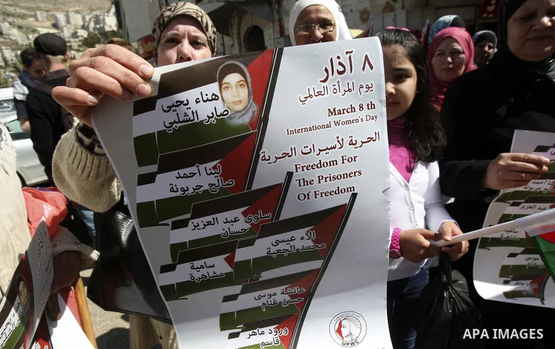 Palestinian women carry banners as they mark International Women's Day in solidarity with Hana Shalabi, a Palestinian prisoner jailed in Israel and who has been on hunger strike for 22 days, in the West Bank in Nablus, T...