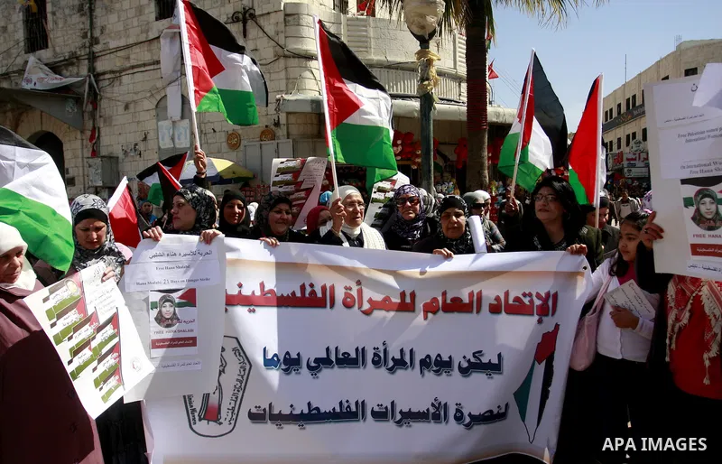 Palestinian women carry banners as they mark International Women's Day in solidarity with Hana Shalabi, a Palestinian prisoner jailed in Israel and who has been on hunger strike for 22 days, in the West Bank in Nablus, T...