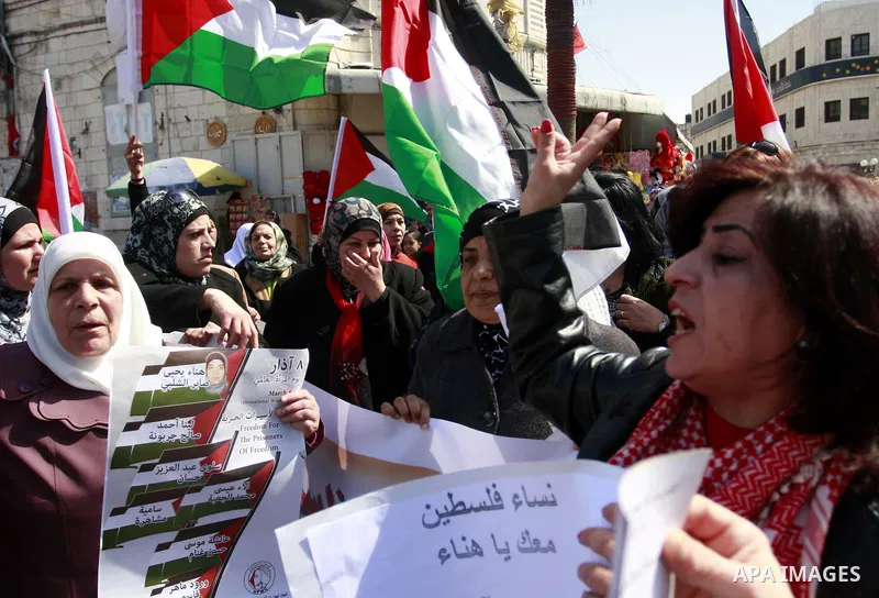 Palestinian women carry banners as they mark International Women's Day in solidarity with Hana Shalabi, a Palestinian prisoner jailed in Israel and who has been on hunger strike for 22 days, in the West Bank in Nablus, T...