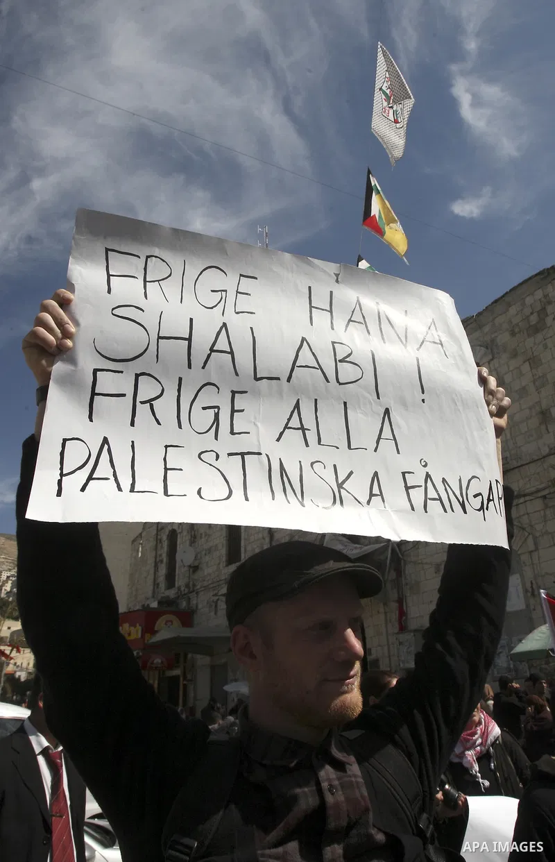 Palestinian women carry banners as they mark International Women's Day in solidarity with Hana Shalabi, a Palestinian prisoner jailed in Israel and who has been on hunger strike for 22 days, in the West Bank in Nablus, T...