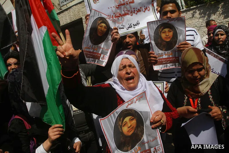 A Palestinian woman hold a poster during a protest calling for the release of Hana Shalabi, a female Palestinian prisoner jailed in Israel who has been on hunger strike for 22 days, outside the Red Cross building in Gaza...