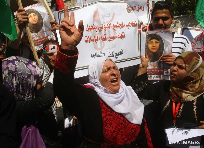 A Palestinian woman hold a poster during a protest calling for the release of Hana Shalabi, a female Palestinian prisoner jailed in Israel who has been on hunger strike for 22 days, outside the Red Cross building in Gaza...