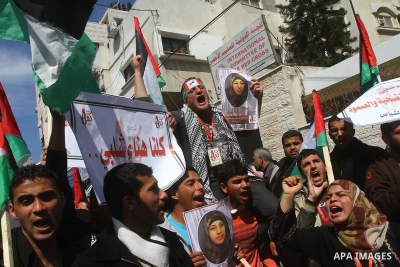 A Palestinian woman hold a poster during a protest calling for the release of Hana Shalabi, a female Palestinian prisoner jailed in Israel who has been on hunger strike for 22 days, outside the Red Cross building in Gaza...