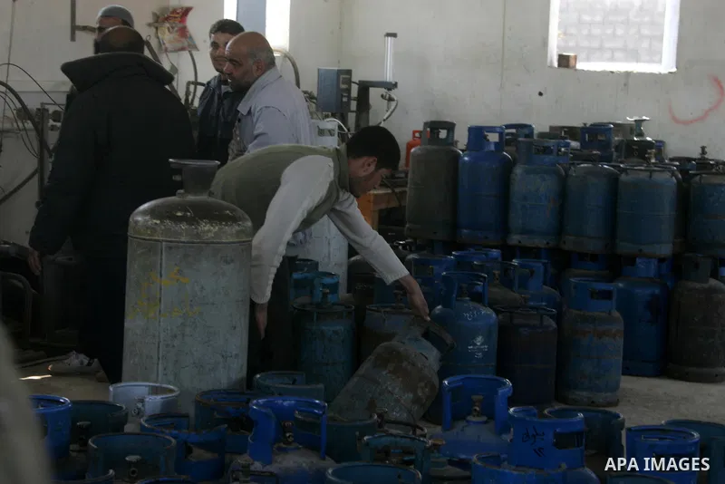 Palestinians wait to fill gas cylinders at a gas filling station in Khan Younis in the southern Gaza Strip March 8, 2012. Photo by Abed Rahim Khatib