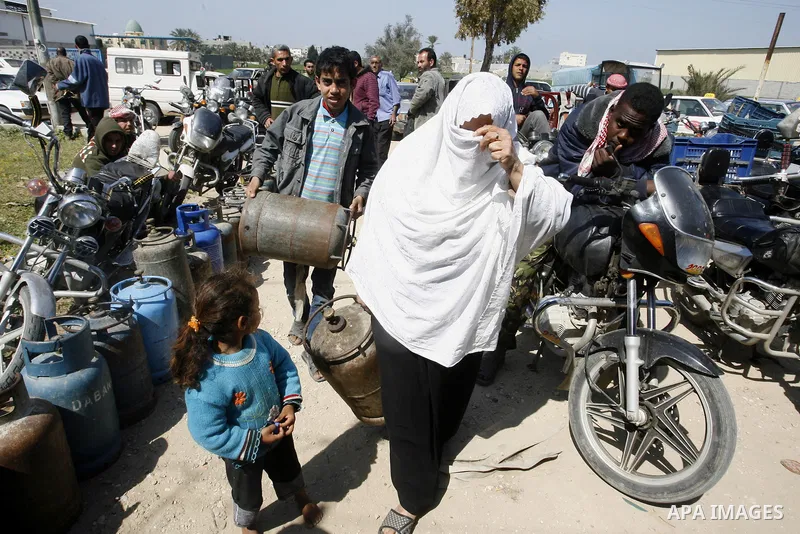 Palestinians wait to fill gas cylinders at a gas filling station in Khan Younis in the southern Gaza Strip March 8, 2012. Photo by Abed Rahim Khatib