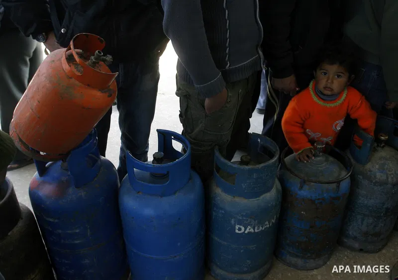 Palestinians wait to fill gas cylinders at a gas filling station in Khan Younis in the southern Gaza Strip March 8, 2012. Photo by Abed Rahim Khatib