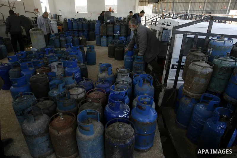 Palestinians wait to fill gas cylinders at a gas filling station in Khan Younis in the southern Gaza Strip March 8, 2012. Photo by Abed Rahim Khatib