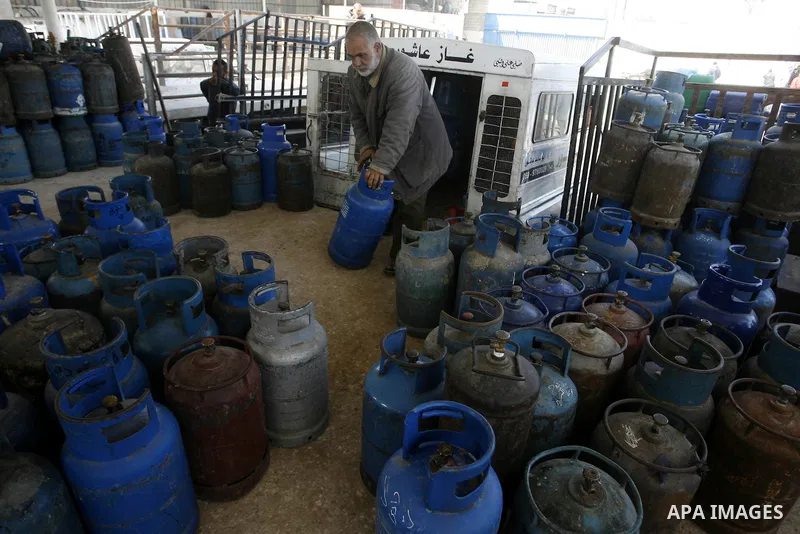 Palestinians wait to fill gas cylinders at a gas filling station in Khan Younis in the southern Gaza Strip March 8, 2012. Photo by Abed Rahim Khatib
