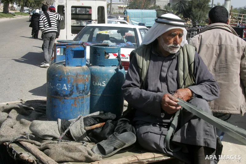 Palestinians wait to fill gas cylinders at a gas filling station in Khan Younis in the southern Gaza Strip March 8, 2012. Photo by Abed Rahim Khatib