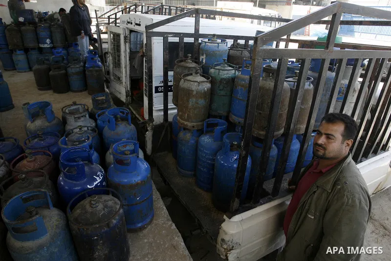 Palestinians wait to fill gas cylinders at a gas filling station in Khan Younis in the southern Gaza Strip March 8, 2012. Photo by Abed Rahim Khatib