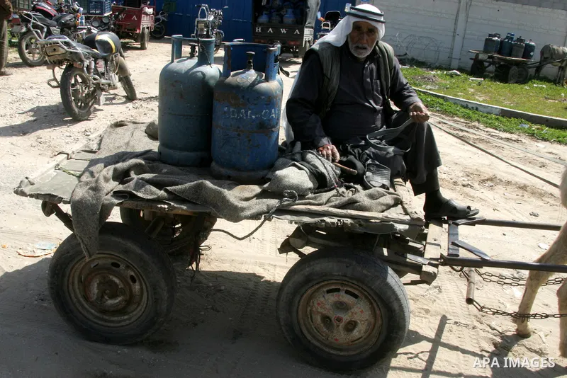 Palestinians wait to fill gas cylinders at a gas filling station in Khan Younis in the southern Gaza Strip March 8, 2012. Photo by Abed Rahim Khatib