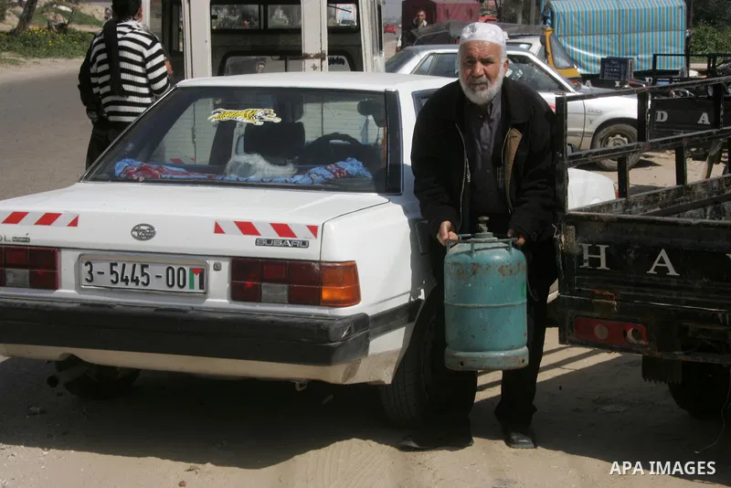 Palestinians wait to fill gas cylinders at a gas filling station in Khan Younis in the southern Gaza Strip March 8, 2012. Photo by Abed Rahim Khatib
