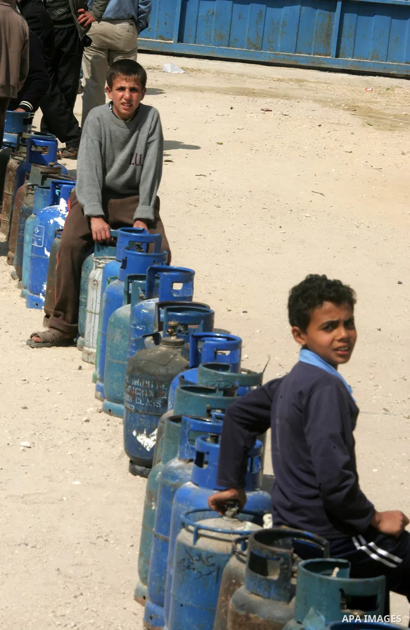 Palestinians wait to fill gas cylinders at a gas filling station in Khan Younis in the southern Gaza Strip March 8, 2012. Photo by Abed Rahim Khatib