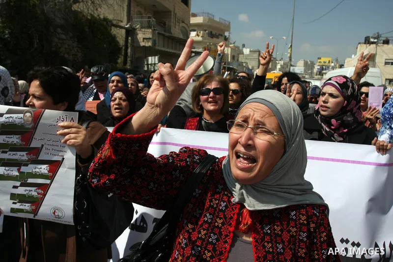 Palestinian woman shout slogans at Israeli soldiers while taking part in a demonstration to remove barriers on Palestinian land, to mark International Women's Day, on March 8, 2012, in the West Bank town of Qalandia. Pho...