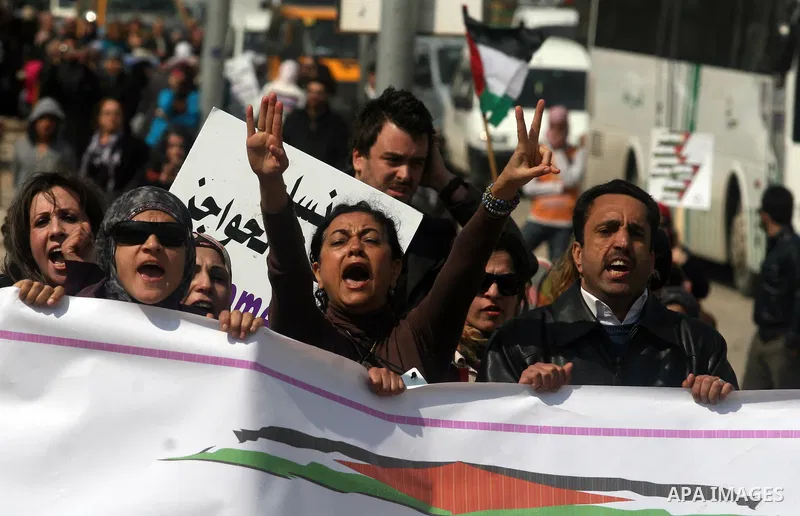 Palestinian woman shout slogans at Israeli soldiers while taking part in a demonstration to remove barriers on Palestinian land, to mark International Women's Day, on March 8, 2012, in the West Bank town of Qalandia. Pho...