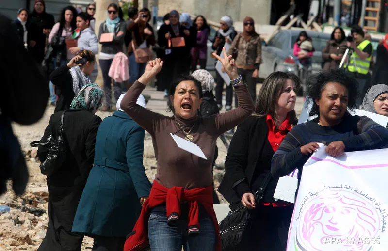 Palestinian woman shout slogans at Israeli soldiers while taking part in a demonstration to remove barriers on Palestinian land, to mark International Women's Day, on March 8, 2012, in the West Bank town of Qalandia. Pho...
