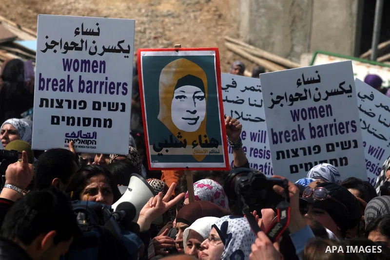 Palestinian woman shout slogans at Israeli soldiers while taking part in a demonstration to remove barriers on Palestinian land, to mark International Women's Day, on March 8, 2012, in the West Bank town of Qalandia. Pho...
